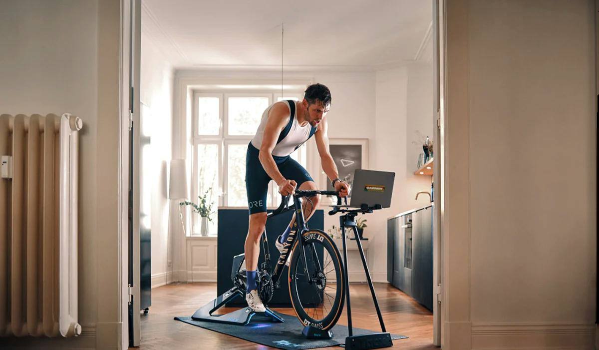 en man på en cykeltrainer inomhus