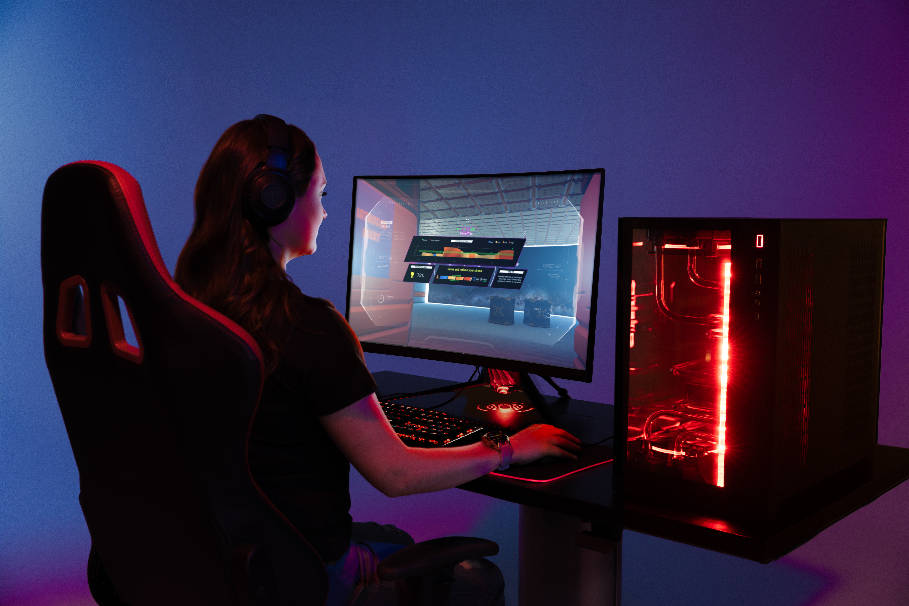 Gamer girl spelar på gaming dator, Garmin smartwatch synlig på handleden.