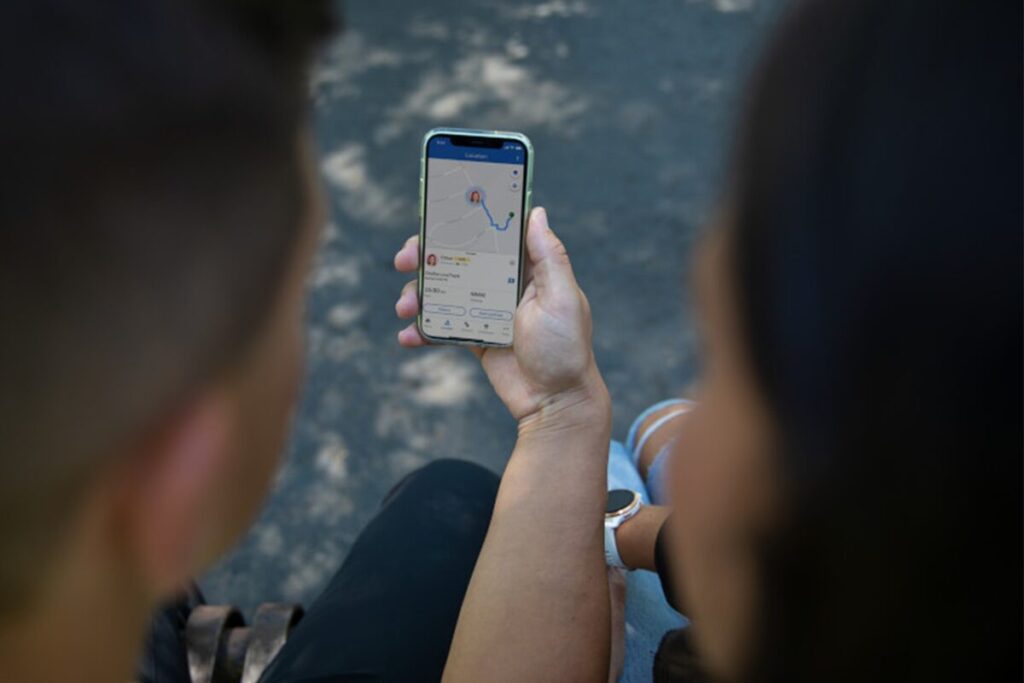 Föräldrar använder smarttelefon för att övervaka sina barns plats via GPS på en digital karta.