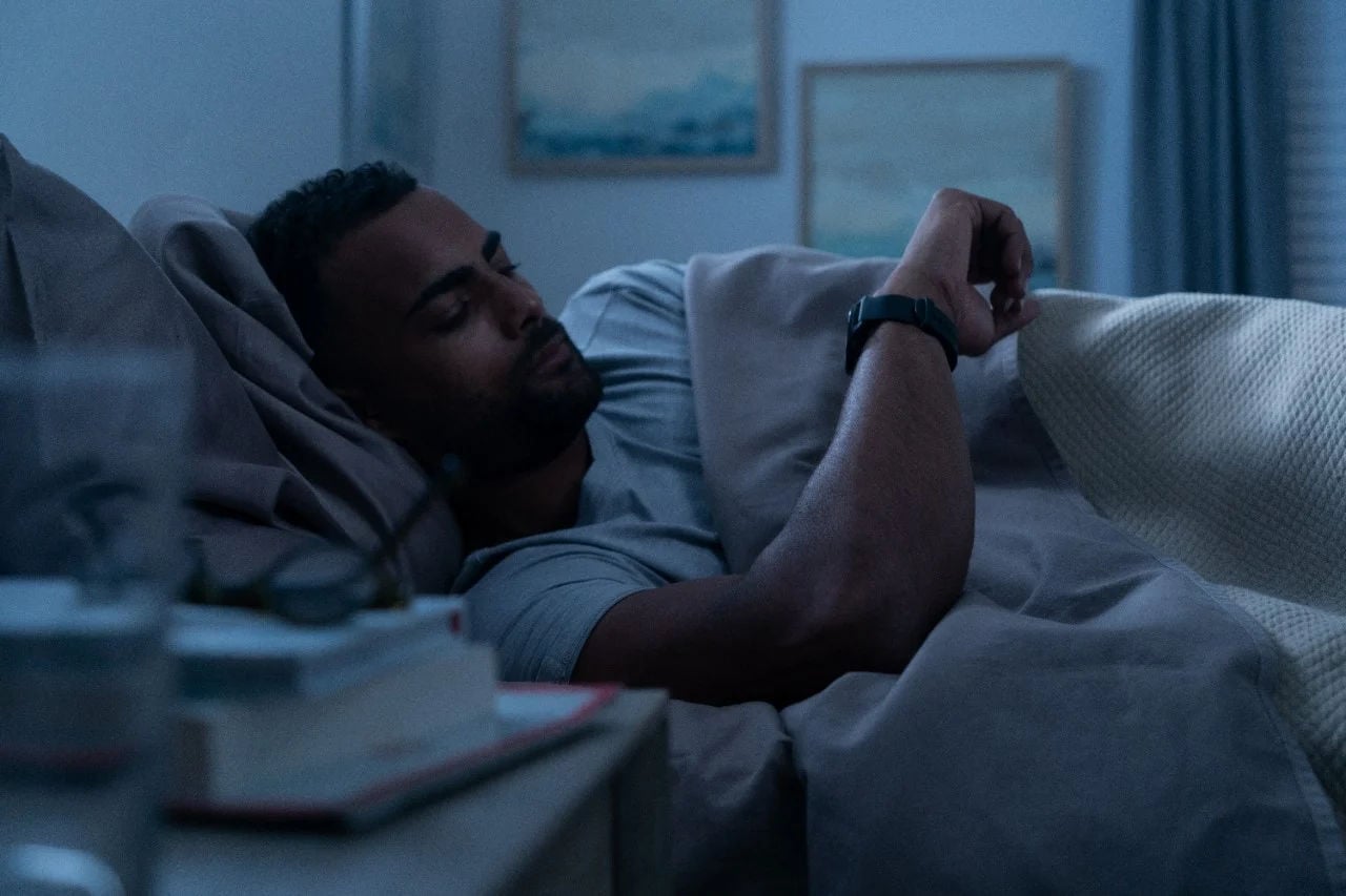 Man sover med en Garmin smartklocka som registrerar sömnkvalitet och Sleep Score