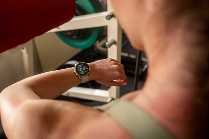 Närbild på Garmin-smartklocka som visar träningsdata under HYROX-pass i gymmiljö.