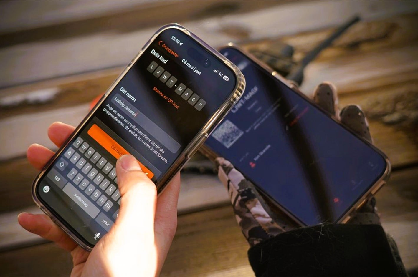 Garmin Alpha app i mobil visar jaktkarta och positioner för gruppjakt i realtid på träbord